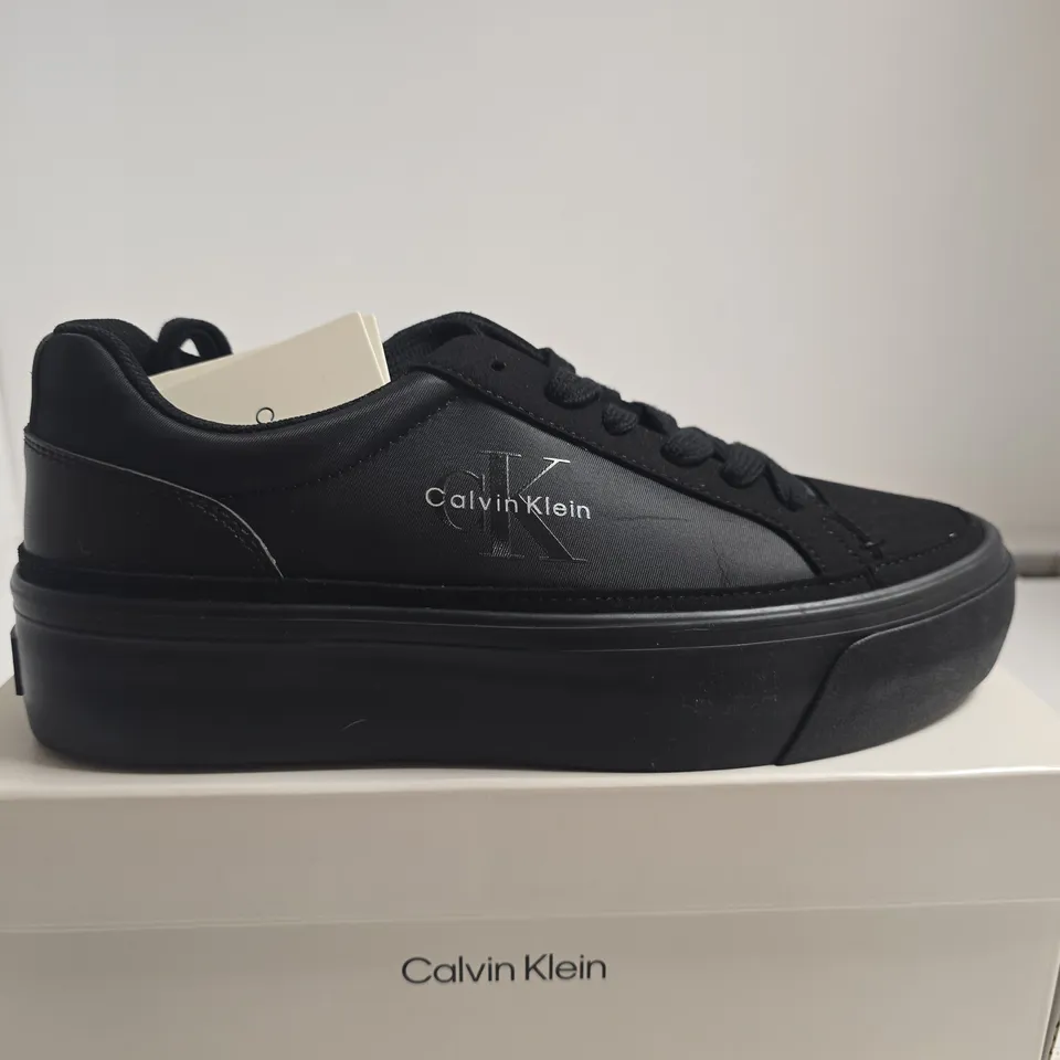 BOXED PAIR OF CALVIN KLEIN BLACK VULC FLAT LACE-UP SNEAKERS – UK5
