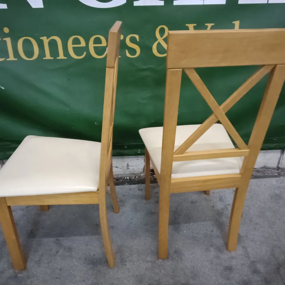 PAIR OF WOODEN DINING CHAIRS WITH CREAM FAUX LEATHER SEAT PADS 