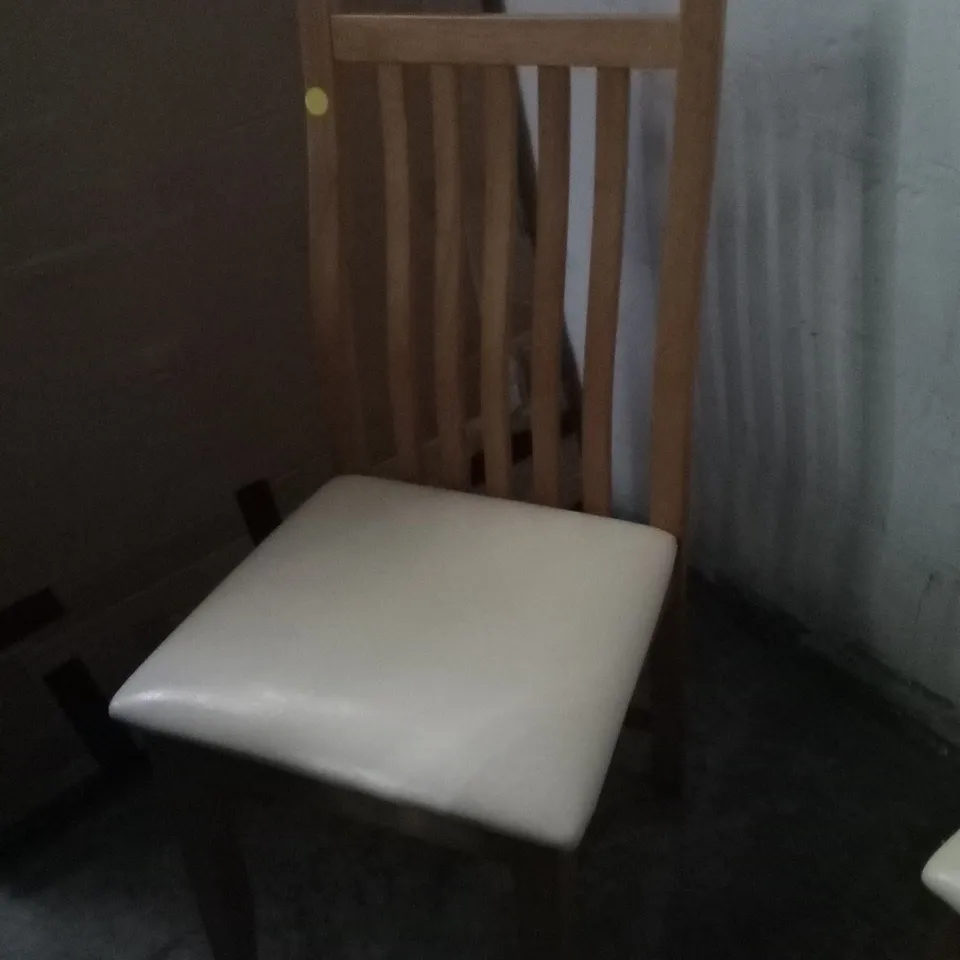PAIR OF OAK EFFECT SLATTED BACK DINING CHAIRS WITH CREAM FAUX LEATHER SEAT PAD