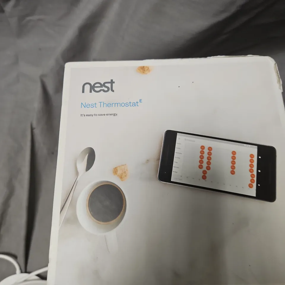 NEST THERMOSTAT E – BOXED WITH POWER ADAPTER AND FABRIC-COVERED THERMOSTAT .