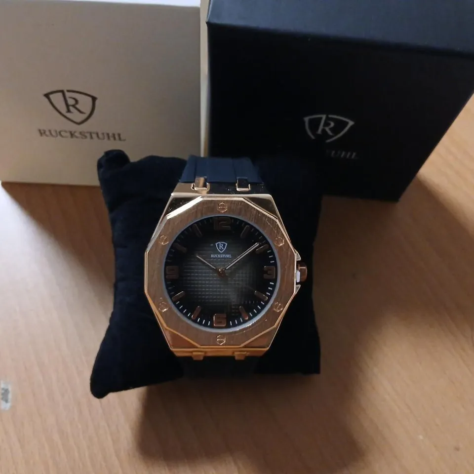 RUCKSTUHL WRISTWATCH – ROSE GOLD-TONE CASE, BLACK STRAP, BLACK DIAL