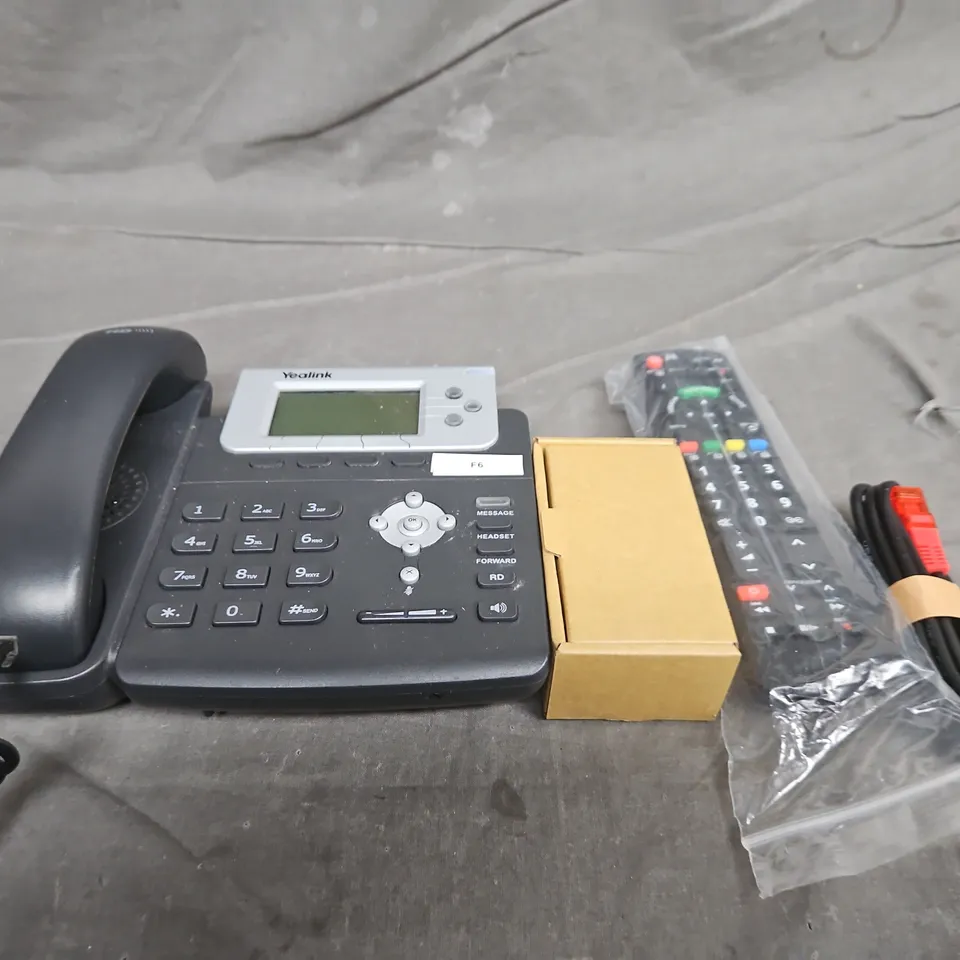 TOTE OF APPROXIMATELY 10 ASSORTED HOUSEHOLD ITEMS TO INCLUDE CABLES, REMOTE CONTROLS AND PHONES