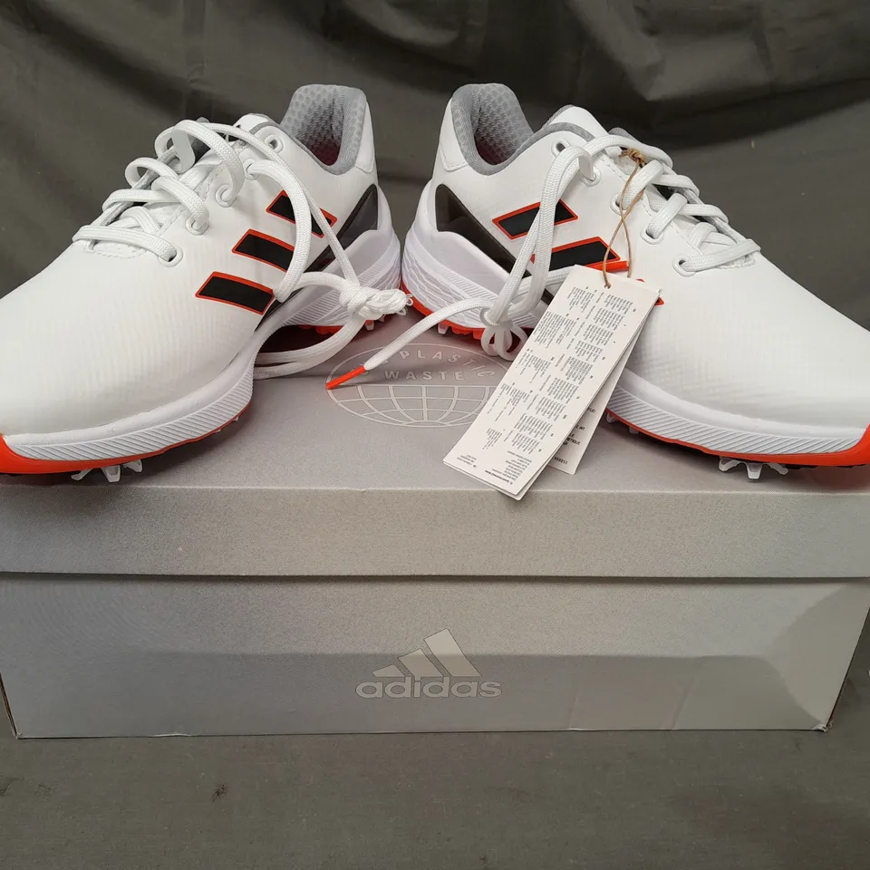 BOXED PAIR OF ADIDAS ZG23 GOLF SHOES IN WHITE/BLACK/ORANGE UK SIZE 7