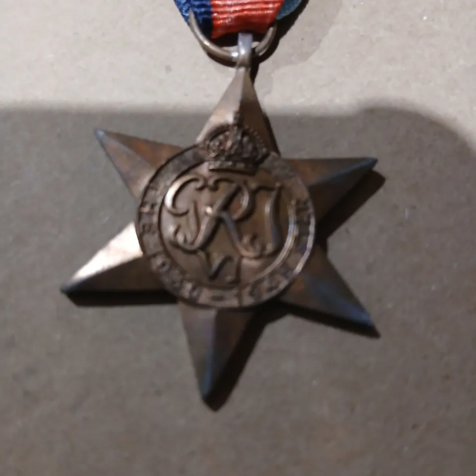 APPROXIMATELY 80 STAR-SHAPED MEDAL ON TRI-COLOR RIBBON ENGRAVED THE 1939-1945 STAR